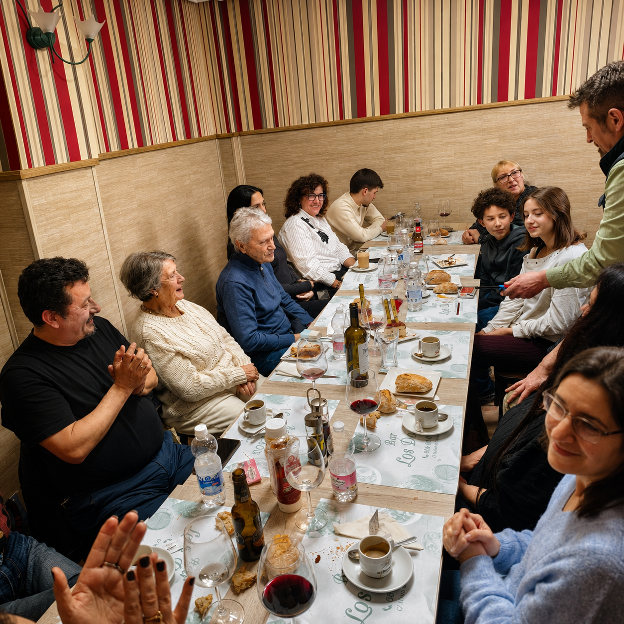 Grupo de clientes celebrando una comida familiar en el comedor de Bar Los Dados en Puerta del Ángel, Madrid.