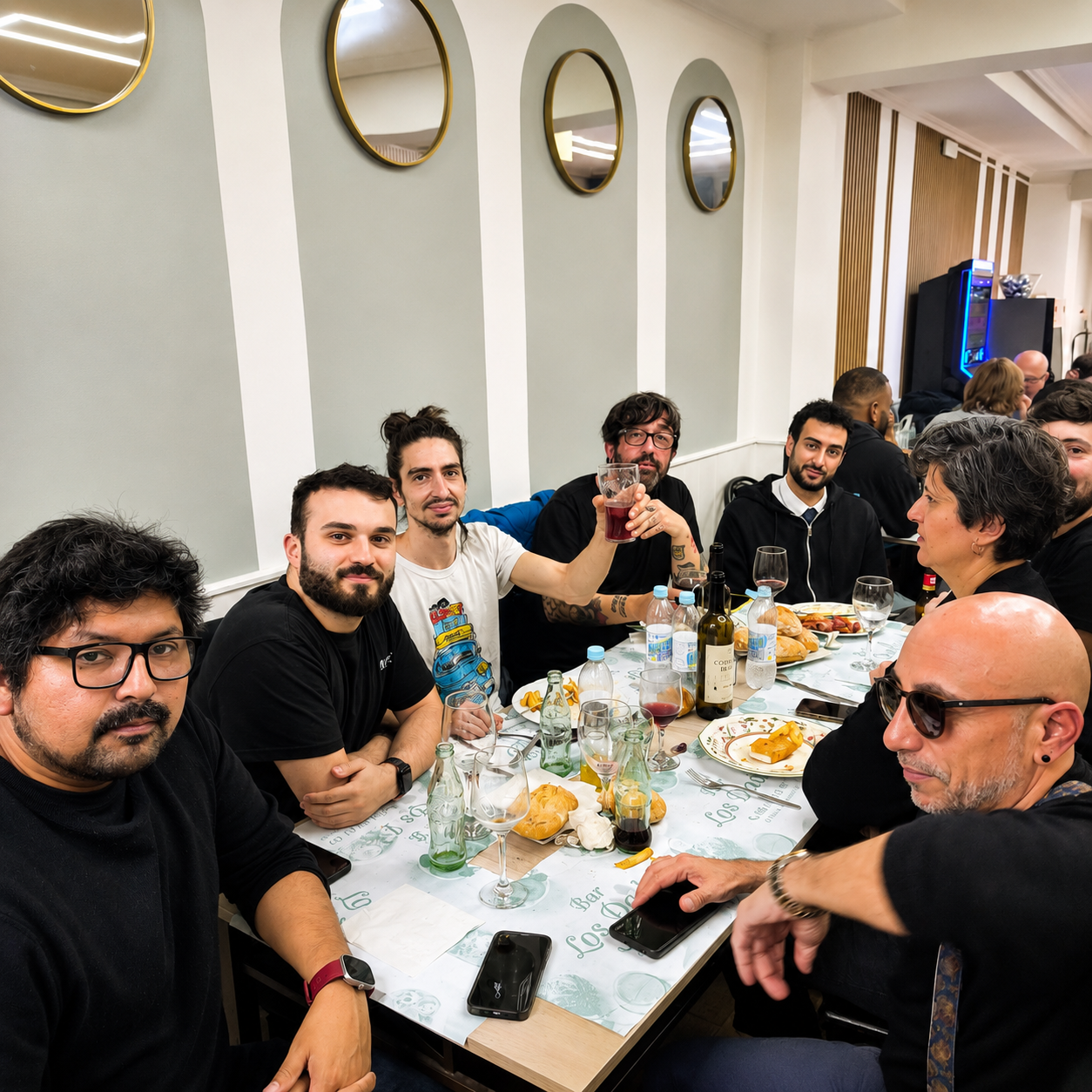 Grupo de amigos disfrutando de una comida y brindando en Bar Los Dados, restaurante de cocina casera en Puerta del Ángel, Madrid.